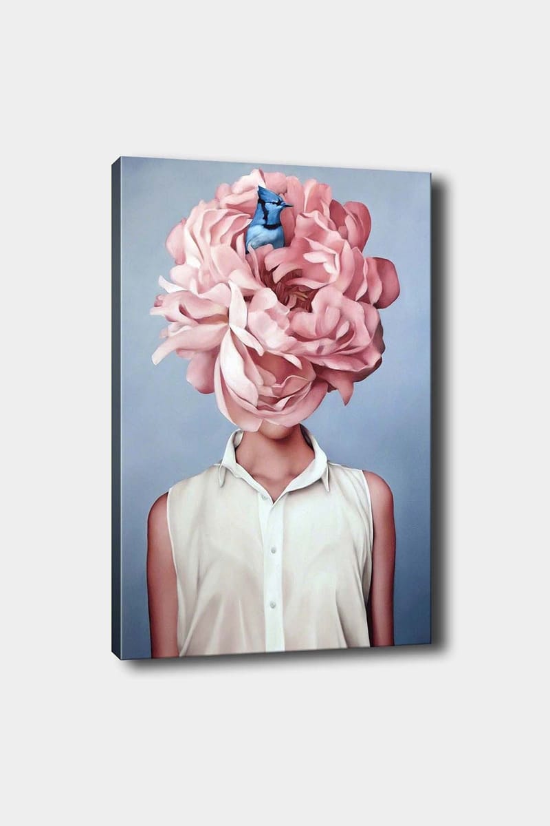 Canvas taulu 70x100 cm - Nainen suuressa vaaleanpunaisessa kukkapäähineessä ja sinisessä linnussa istumassa kukkien keskellä, Vaaleanpunainen / Sininen / Beige