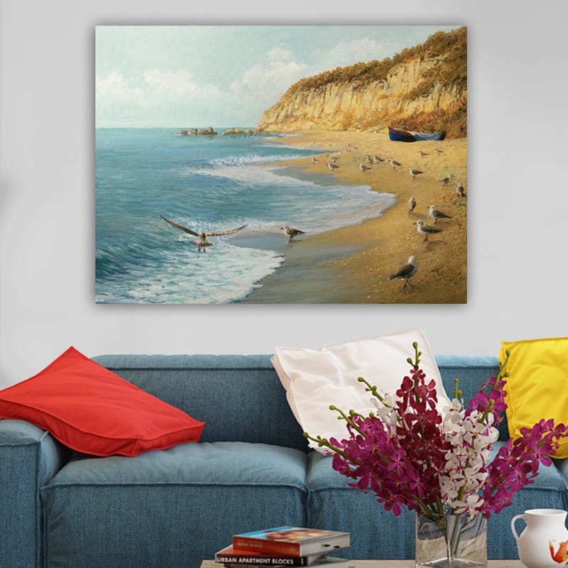 Canvas taulu 70x100 cm - Rantamaisema, jossa linnut lentävät ja kävelevät veden äärellä, kivien ja rannalla olevan veneen ympäröimänä - Sininen / Beige / Vihreä - Sisustustuotteet - Taulu & taide - Canvas-taulu
