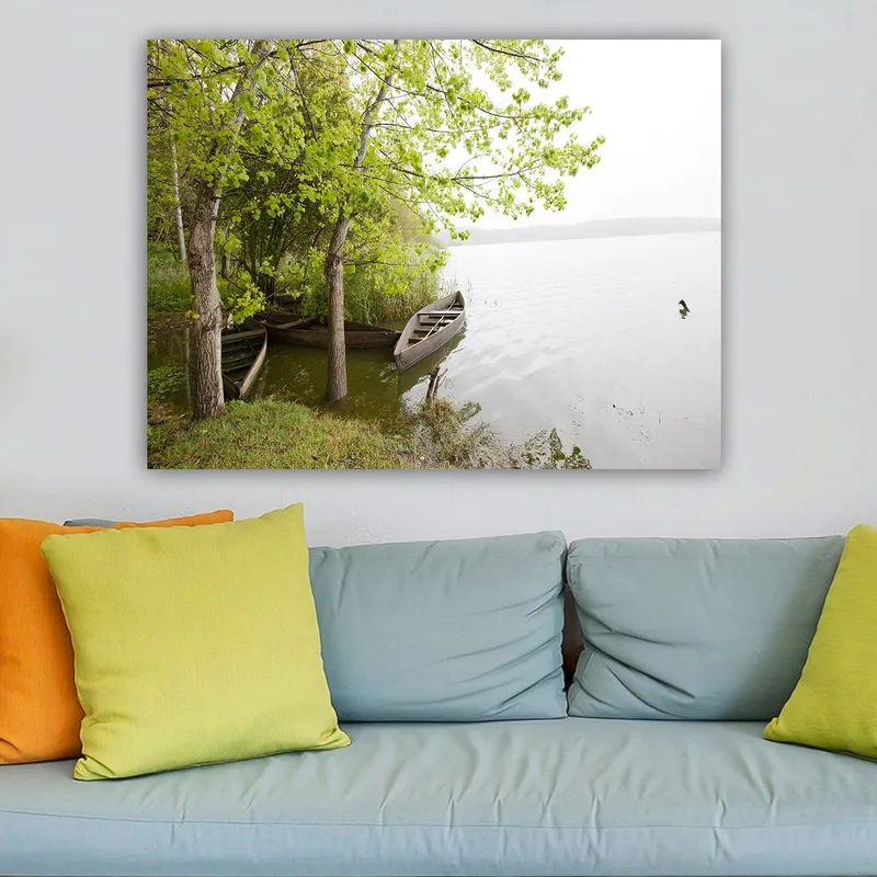 Canvas taulu 70x100 cm - Rauhallinen järvimaisema veneiden ja rehevien puiden kanssa veden äärellä, Vihreä / Ruskea / Harmaa