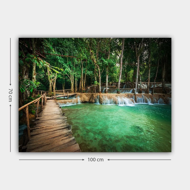 Canvas taulu 70x100 cm - Rauhallinen ja luonnonkaunis paikka, jossa puinen silta johtaa kirkkaan, turkoosin vesiputousaltaan yli rehevän vehreyden ympäröimänä - Turkoosi / Vihreä / Ruskea - Sisustustuotteet - Taulu & taide - Canvas-taulu