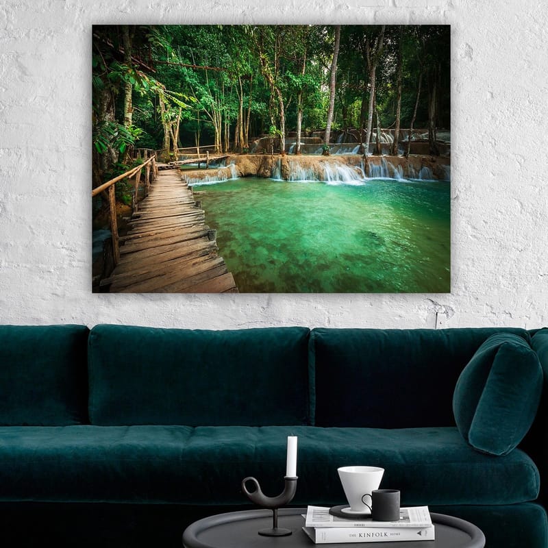 Canvas taulu 70x100 cm - Rauhallinen ja luonnonkaunis paikka, jossa puinen silta johtaa kirkkaan, turkoosin vesiputousaltaan yli rehevän vehreyden ympäröimänä - Turkoosi / Vihreä / Ruskea - Sisustustuotteet - Taulu & taide - Canvas-taulu