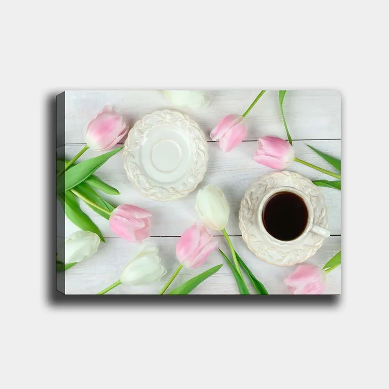 Canvas taulu 70x100 cm - Rauhallinen kattaus kupin kahvin ja vaaleanpunaisten ja valkoisten tulppaanien kera, Vaaleanpunainen / Valkoinen / Vihreä
