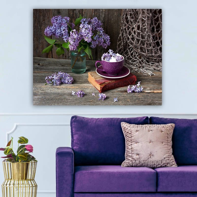 Canvas taulu 70x100 cm - Rauhallinen luontomaalaus, jossa violetteja syreenejä lasimaljakossa ja violetti kuppi vanhan kirjan päällä, Violetti / Vihreä / Ruskea