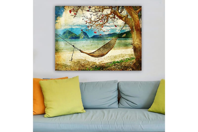 Canvas taulu 70x100 cm - Rentouttava riippumatto puiden oksien välissä kauniilla rannalla, taustalla kaukaiset vuoret - Vihreä / Ruskea / Sininen - Sisustustuotteet - Taulu & taide - Canvas-taulu