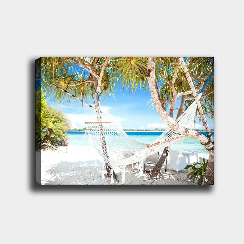 Canvas taulu 70x100 cm - Rentouttava riippumatto palmujen välissä rannalla, jossa on turkoosi vesi ja kirkas sininen taivas, Valkoinen / Sininen / Vihreä