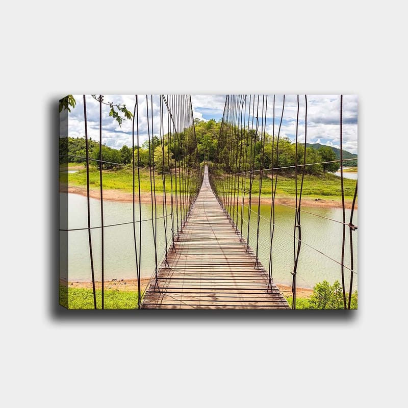 Canvas taulu 70x100 cm - Riippusilta tyynen järven yli, rehevän vehreyden ympäröimänä, Vihreä / Ruskea / Sininen
