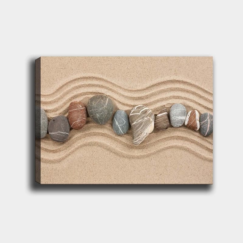 Canvas taulu 70x100 cm - Rivi sileitä kiviä hiekkapinnalla aaltoilevilla kuvioilla, Hiekanbeige / Harmaa / Punaruskea