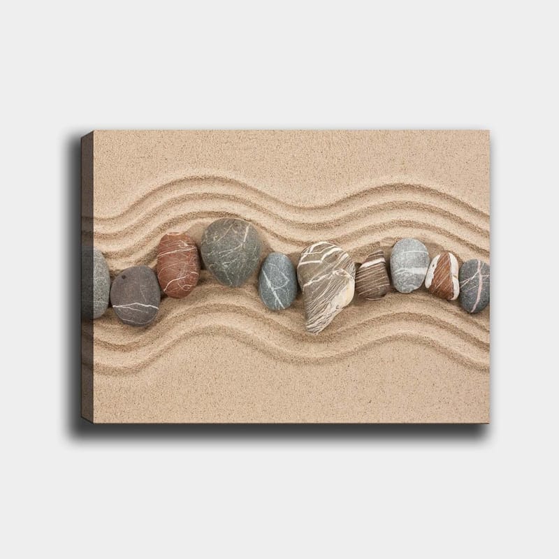 Canvas taulu 70x100 cm - Rivi sileitä kiviä hiekkapinnalla aaltoilevilla kuvioilla, Hiekanbeige / Harmaa / Punaruskea