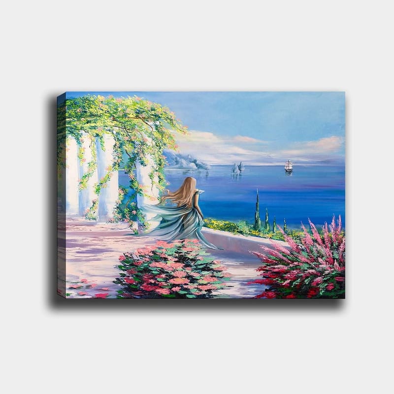 Canvas taulu 70x100 cm - Sinipukuinen nainen seisoo näköalapaikalla meren ja purjeveneiden taustalla, Sininen / Vihreä / Vaaleanpunainen