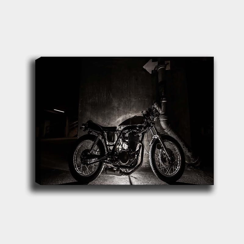 Canvas taulu 70x100 cm - Tyylikäs moottoripyörä kaupunkiympäristössä, jossa keskitytään yksityiskohtiin ja varjoihin, Musta / Harmaa