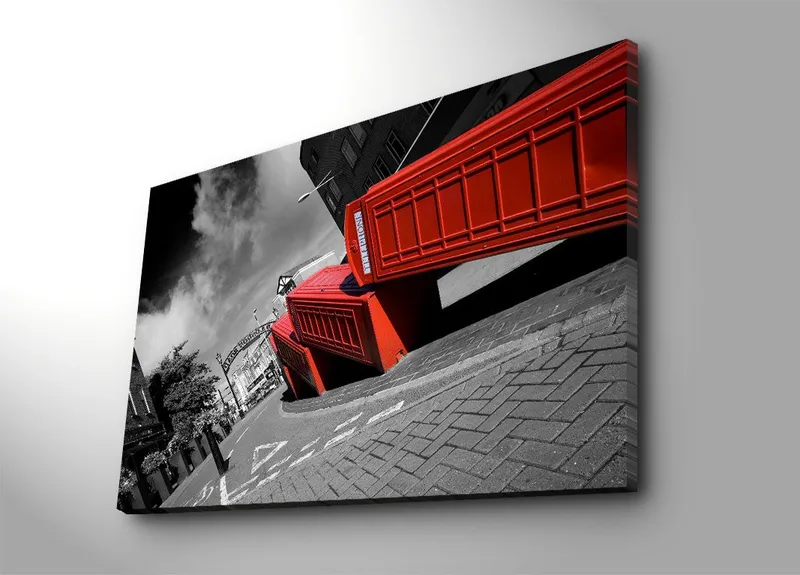 Canvas taulu 70x100 cm - Tyylitelty kuva punaisista puhelinkopeista mustavalkoisessa kaupunkikuvassa, Punainen / Musta