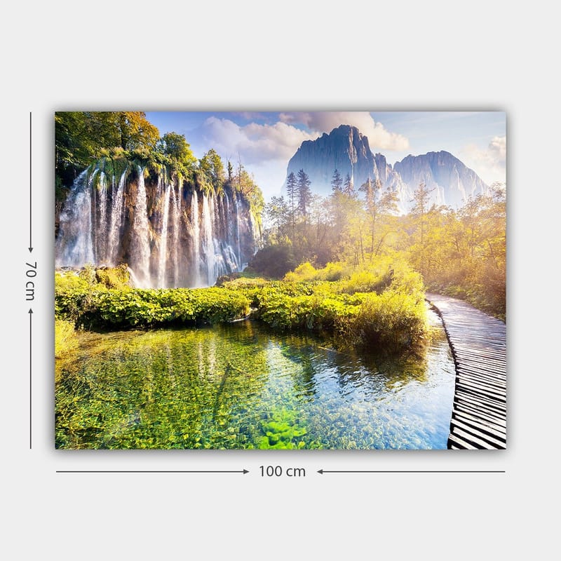Canvas taulu 70x100 cm - Upea vesiputousmaisema rehevän kasvillisuuden ja majesteettisten vuorten ympäröimänä - Vihreä / Sininen / Keltainen - Sisustustuotteet - Taulu & taide - Canvas-taulu
