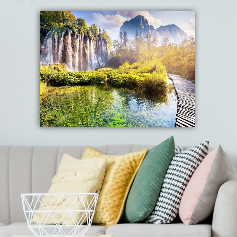 Canvas taulu 70x100 cm - Upea vesiputousmaisema rehevän kasvillisuuden ja majesteettisten vuorten ympäröimänä - Vihreä / Sininen / Keltainen - Sisustustuotteet - Taulu & taide - Canvas-taulu