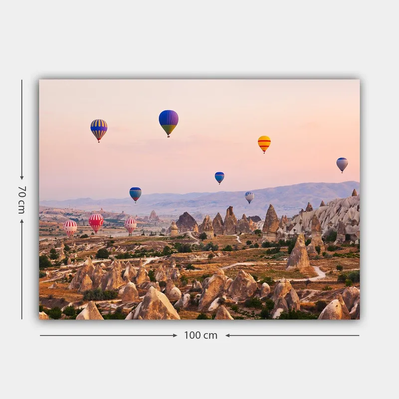 Canvas taulu 70x100 cm - Useita värikkäitä kuumailmapalloja leijuu dramaattisen maiseman ja ainutlaatuisten kalliomuodostelmien yllä - Sininen / Punainen / Oranssi - Sisustustuotteet - Taulu & taide - Canvas-taulu