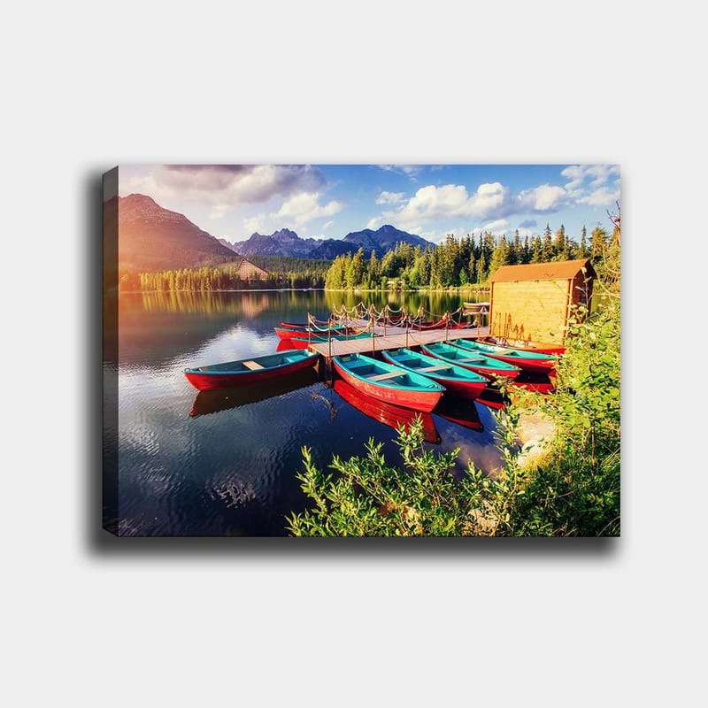 Canvas taulu 70x100 cm - Useita värikkäitä veneitä makaa peilimäisellä järvellä rehevien puiden ja vuorten ympäröimänä, Punainen / Turkoosi / Vihreä