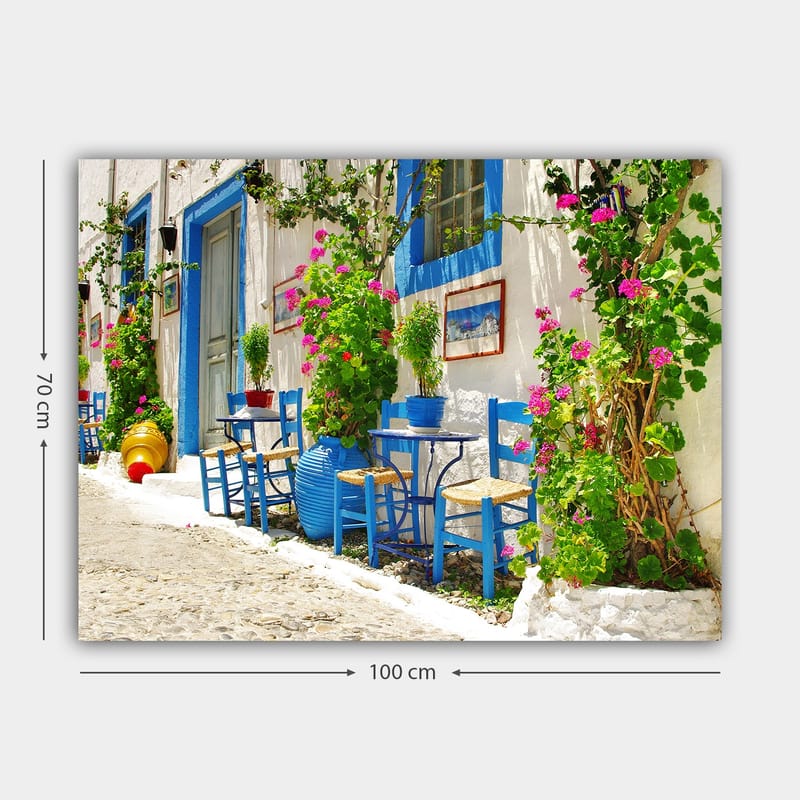 Canvas taulu 70x100 cm - Värikäs ja eloisa katu sinisine tuoleineen ja kukkaruukkuineen välimerellisessä ympäristössä - Sininen / Vihreä / Vaaleanpunainen - Sisustustuotteet - Taulu & taide - Canvas-taulu