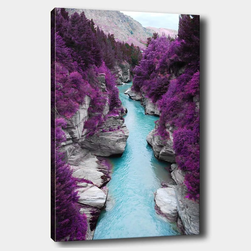 Canvas taulu 70x100 cm - Värikäs joki mutkittelee vuoren rotkon läpi, jota ympäröivät violetit puut ja kivet, Violetti / Turkoosi