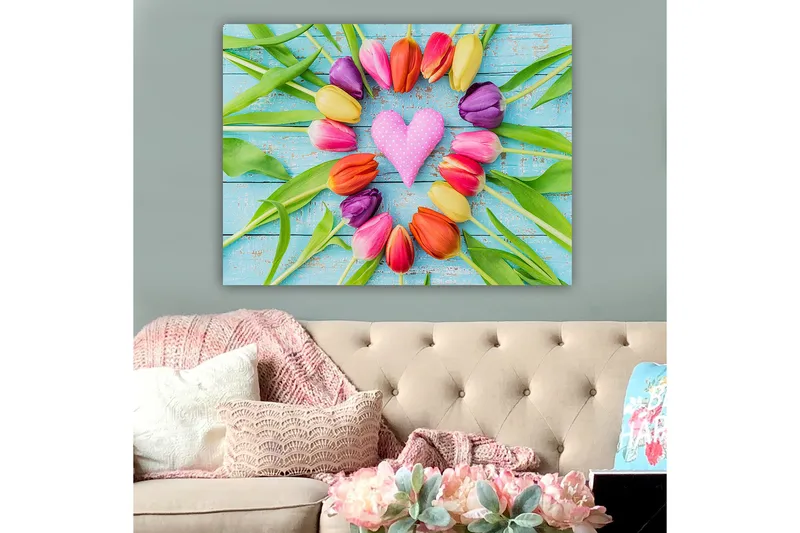 Canvas taulu 70x100 cm - Värikäs kokoelma sydämen muotoisia tulppaaneja, joiden keskellä on vaaleanpunainen koriste - Vaaleanpunainen / Violetti / Oranssi - Sisustustuotteet - Taulu & taide - Canvas-taulu