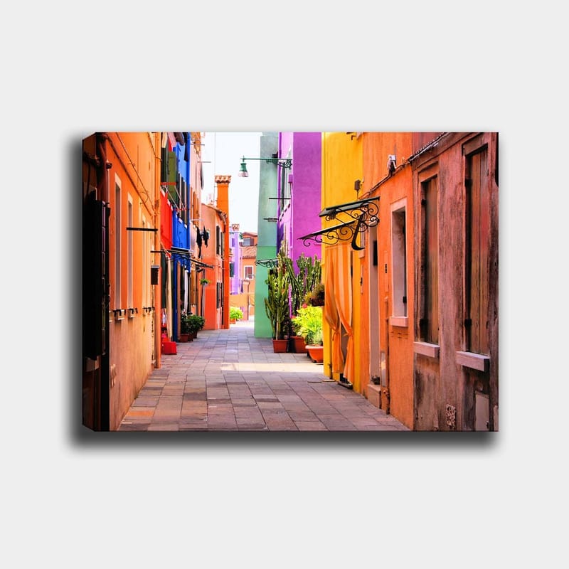 Canvas taulu 70x100 cm - Värikäs kuja ja eloisia taloja eri sävyissä, Oranssi / Violetti / Vihreä