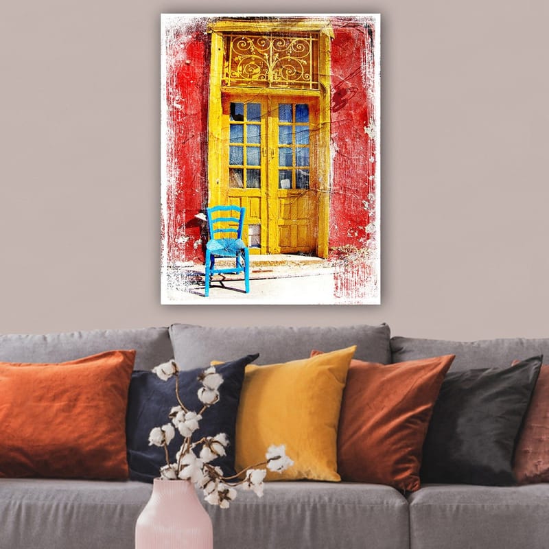 Canvas taulu 70x100 cm - Värikäs ovi ja sen edessä sininen tuoli punaisella seinällä - Keltainen / Punainen / Sininen - Sisustustuotteet - Taulu & taide - Canvas-taulu