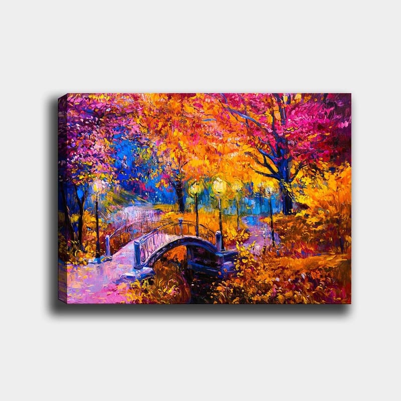 Canvas taulu 70x100 cm - Värikäs syysmaisema, jossa tyynen veden pinnan ylittävä silta, lämpimien syysvärien puiden ympäröimänä, Oranssi / Violetti / Keltainen