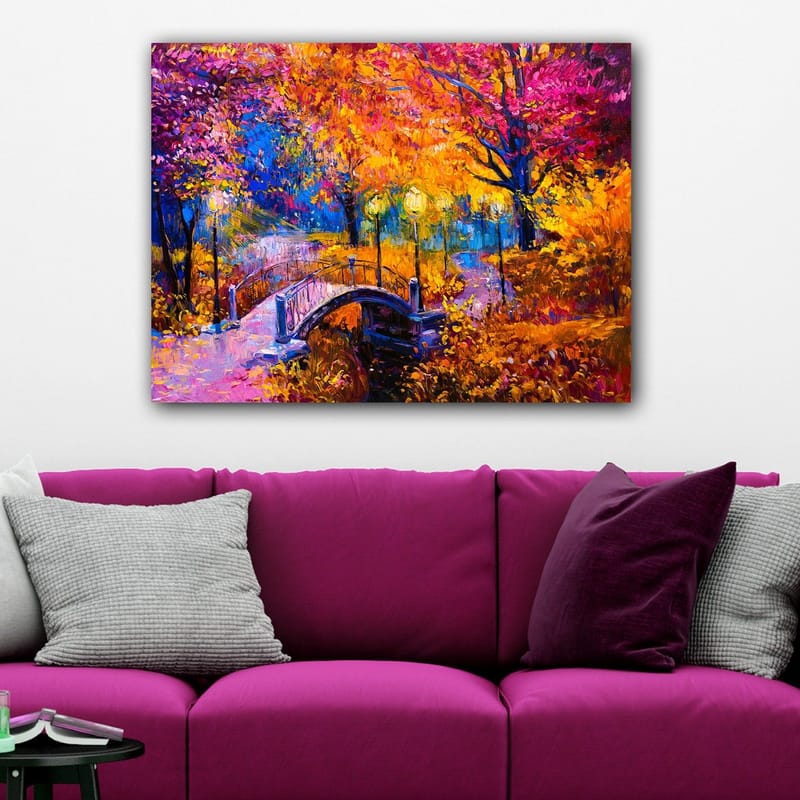 Canvas taulu 70x100 cm - Värikäs syysmaisema, jossa tyynen veden pinnan ylittävä silta, lämpimien syysvärien puiden ympäröimänä - Oranssi / Violetti / Keltainen - Sisustustuotteet - Taulu & taide - Canvas-taulu