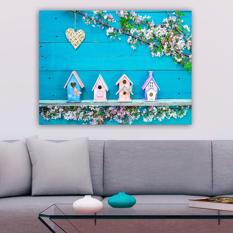 Canvas taulu 70x100 cm - Värikkäät linnunpöntöt sinisellä pohjalla ja kukat koristeena, Sininen / Vaaleanpunainen / Valkoinen