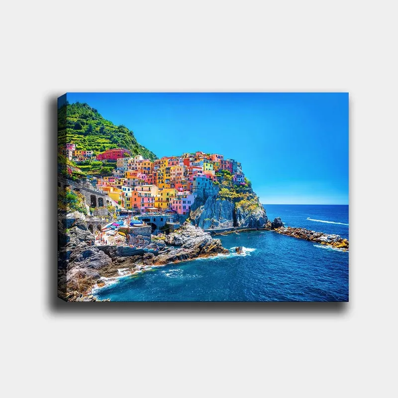 Canvas taulu 70x100 cm - Värikkäät talot kiipeävät kalliolle meren rannalla, Sininen / Keltainen / Vaaleanpunainen