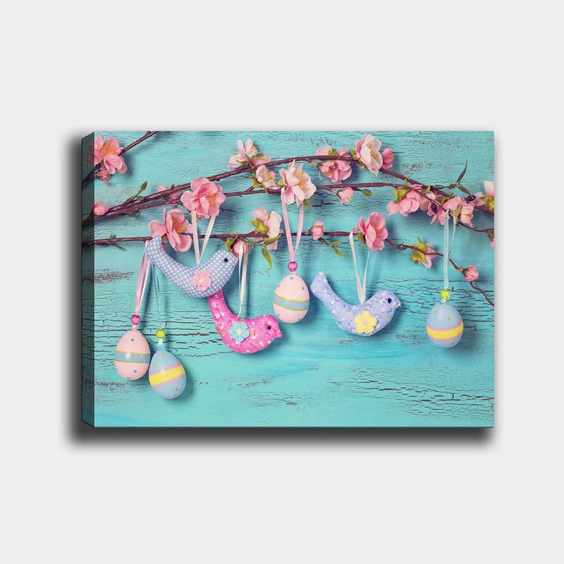 Canvas taulu 70x100 cm - Värikkäitä lintuja ja munia roikkumassa oksalla kukkien kanssa, Sininen / Vaaleanpunainen / Vihreä