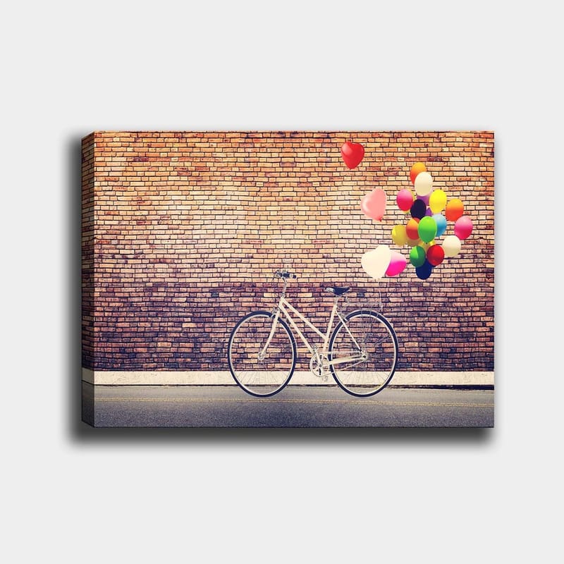 Canvas taulu 70x100 cm - Valkoinen polkupyörä, jonka yllä leijuu värikkäitä ilmapalloja tiiliseinää vasten, Valkoinen / Punainen / Keltainen