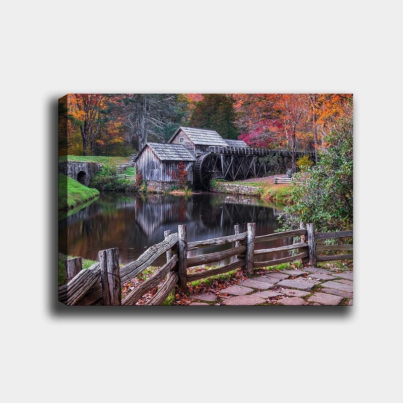 Canvas taulu 70x100 cm - Vanha mylly peilimäisen järven rannalla syksyn väreissä, Punainen / Vihreä / Ruskea