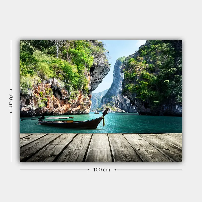 Canvas taulu 70x100 cm - Vene makaa paikallaan kallioisella rannalla rehevien vuorten ja kirkkaan veden ympäröimänä - Vihreä / Sininen / Ruskea - Sisustustuotteet - Taulu & taide - Canvas-taulu