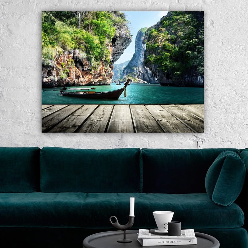Canvas taulu 70x100 cm - Vene makaa paikallaan kallioisella rannalla rehevien vuorten ja kirkkaan veden ympäröimänä - Vihreä / Sininen / Ruskea - Sisustustuotteet - Taulu & taide - Canvas-taulu