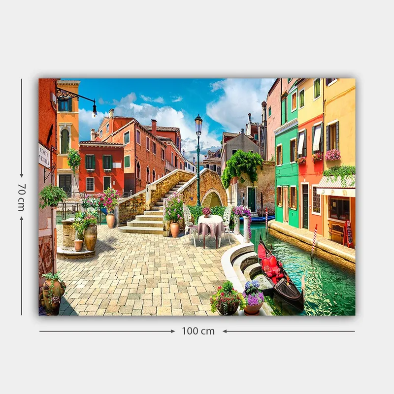 Canvas taulu 70x100 cm - Viehättävä kanava värikkäine taloineen ja kukkakoristeineen viehättävässä italialaisessa kaupunkiympäristössä - Punainen / Vihreä / Keltainen - Sisustustuotteet - Taulu & taide - Canvas-taulu