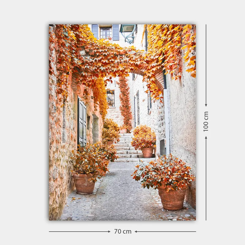 Canvas taulu 70x100 cm - Viehättävä kuja, jota ympäröivät värikkäät syksyn lehdet ja ruukkukasvit - Oranssi / Ruskea / Keltainen - Sisustustuotteet - Taulu & taide - Canvas-taulu