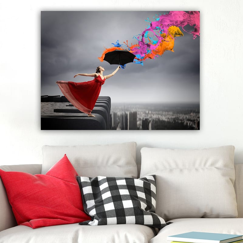Canvas taulu 70x100 cm - Punamekkoinen nainen seisoo reunalla sateenvarjo kädessään, ja siitä suihkuaa värikkäitä maalisuihkuja - Punainen / Musta / Oranssi - Sisustustuotteet - Taulu & taide - Canvas-taulu