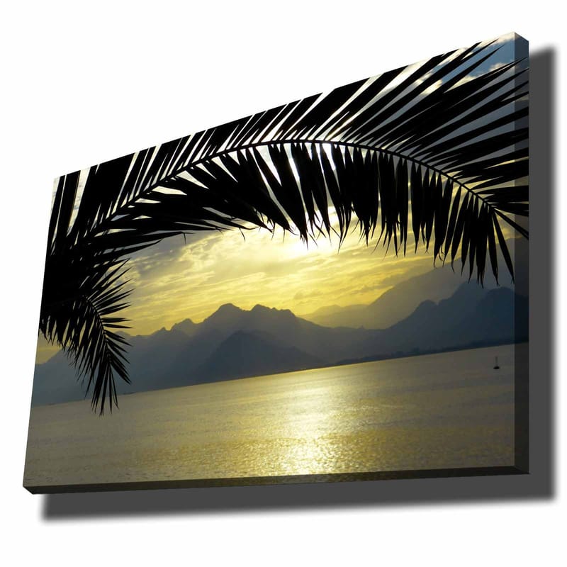 Canvas taulu 70x100 cm - Palmujen siluetti kultaista auringonlaskua vasten vuorten ja meren yllä, Musta / Kulta / Harmaa