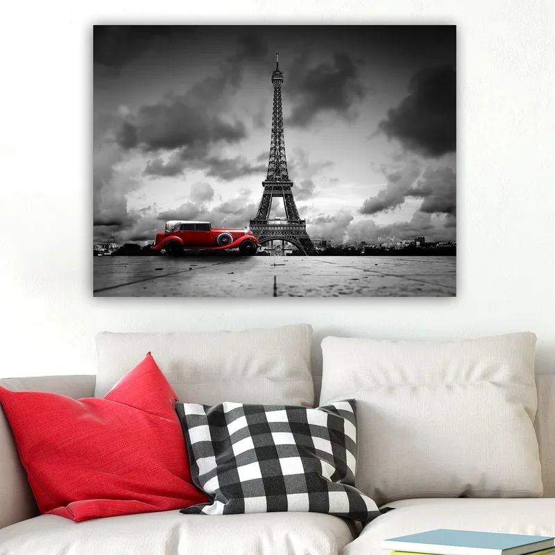 Canvas taulu 70x100 cm - Punainen vintage-auto Eiffel-tornin edessä mustavalkoisessa kaupunkiympäristössä, Punainen / Musta / Valkoinen