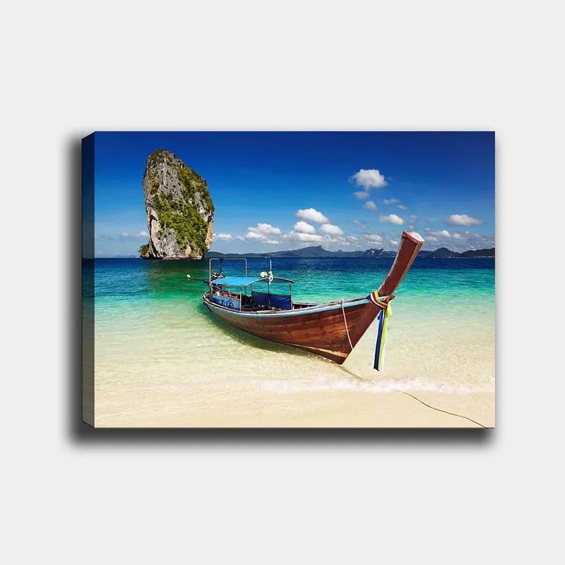 Canvas taulu 70x100 cm - Perinteinen vene trooppisella rannalla, taustalla kivimuodostelmia, Sininen / Vihreä / Ruskea