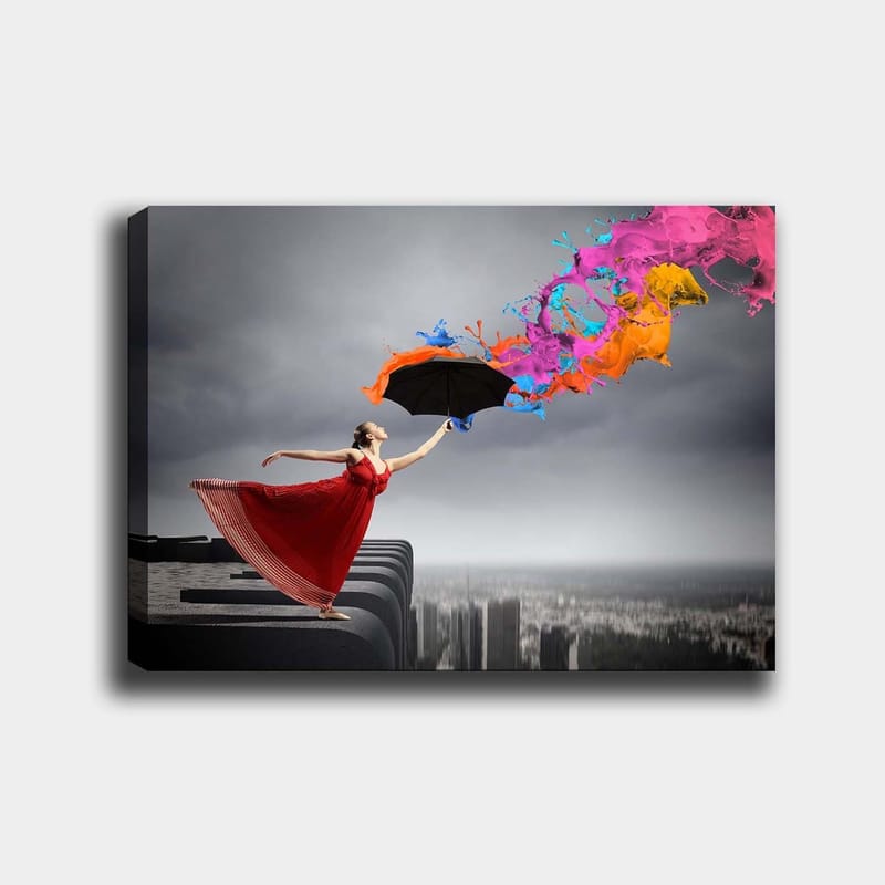 Canvas taulu 70x100 cm - Punamekkoinen nainen seisoo reunalla sateenvarjo kädessään, ja siitä suihkuaa värikkäitä maalisuihkuja, Punainen / Musta / Oranssi