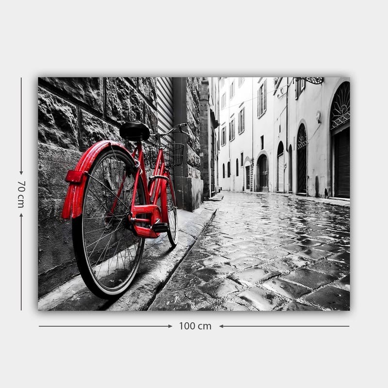 Canvas taulu 70x100 cm - Punainen polkupyörä nojaa seinään mustavalkoisessa kaupunkiympäristössä - Punainen / Musta / Harmaa - Sisustustuotteet - Taulu & taide - Canvas-taulu