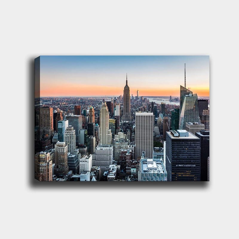 Canvas taulu 70x100 cm - Panoraamanäkymä New York Cityyn ja ikonisiin pilvenpiirtäjiin auringonlaskun valossa, Sininen / Harmaa / Oranssi