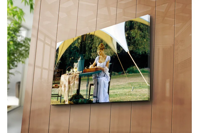 Canvas-taulu 70x45 cm - Nainen kirjoittaa pöydän ääressä teltan alla rehevässä ympäristössä, Vihreä / Valkoinen / Sininen