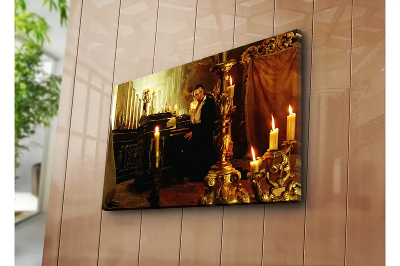Canvas-taulu 70x45 cm - Synkkä ja salaperäinen näkymä miehestä pianon ääressä hehkuvien kynttilöiden ympäröimänä, Kulta / Musta / Ruskea
