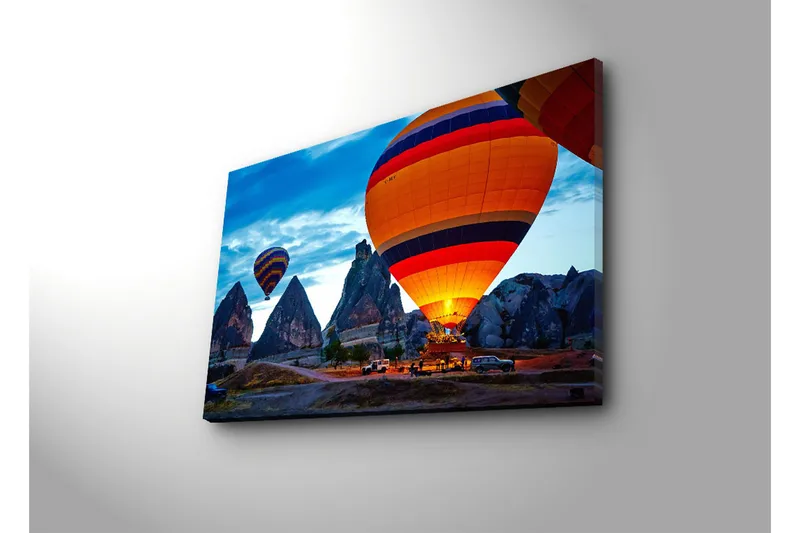 Canvas-taulu 70x45 cm - Värikkäät kuumailmapallot leijuvat dramaattisten kallioiden yllä kirkkaalla taivaalla - Oranssi / Sininen / Harmaa - Sisustustuotteet - Taulu & taide - Canvas-taulu