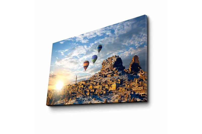 Canvas-taulu 70x45 cm - Värikkäät kuumailmapallot leijuvat viehättävän vuoristokylän yllä auringonnousun aikaan - Kulta / Sininen / Oranssi - Sisustustuotteet - Taulu & taide - Canvas-taulu