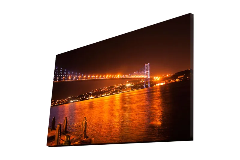 Canvas-taulu 70x45 cm - Valaistu silta kimaltelevan veden pinnan yli iltahämärässä, Tummansininen / Oranssi / Musta
