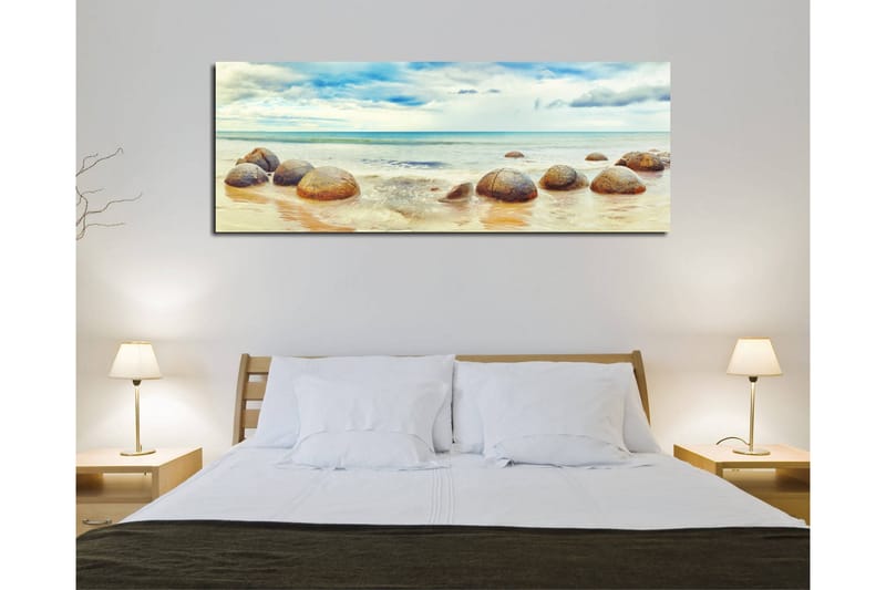 Canvas-taulu 80x30 cm - Pyöreitä kiviä rannalla, taustalla meri ja taivas - Sininen / Beige / Harmaa - Sisustustuotteet - Taulu & taide - Canvas-taulu