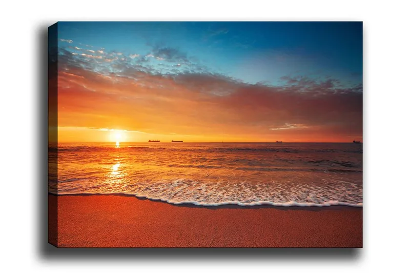 Canvas-taulu - Auringonlasku meren yllä pehmeillä aalloilla rannalla, Oranssi / Sininen / Beige