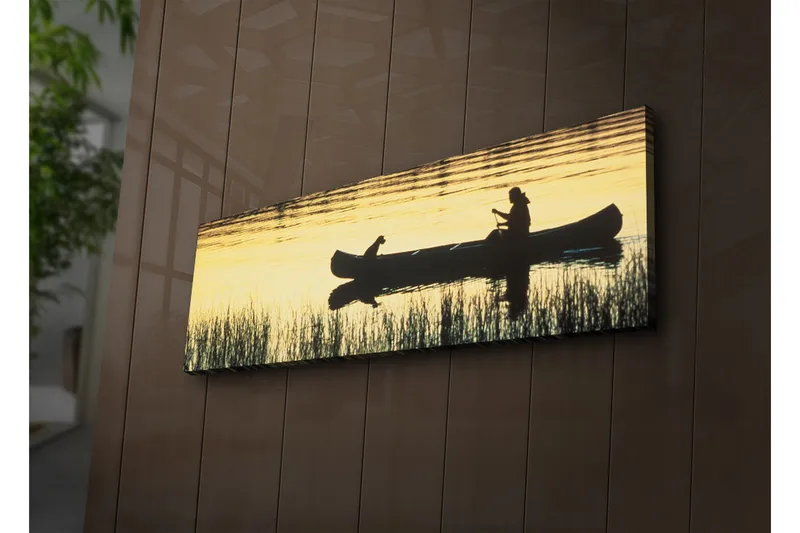 Canvas-taulu LED-valaistuksella 30x90 cm - Kanootin siluetti, ihminen ja koira auringonlaskun valossa, Kulta / Musta